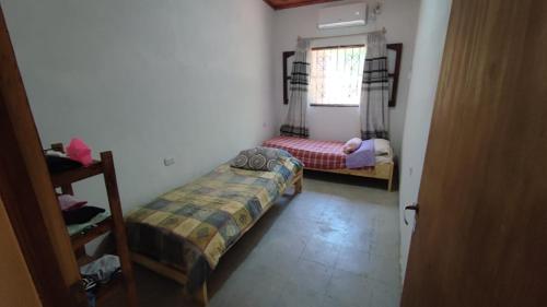 a bedroom with two beds and a window at Finca con pileta Lasmaria in Santiago del Estero
