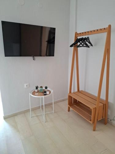 a room with a table and a shelf and a tv at Kozani room with a view! in Kozani