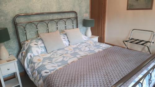 a bedroom with a bed with a metal headboard at 2 Mill Cottages in Cornworthy
