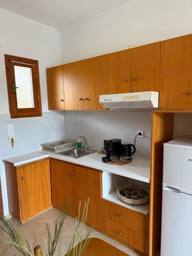 a kitchen with wooden cabinets and a sink at Evita Luxury Apartments in Spilia