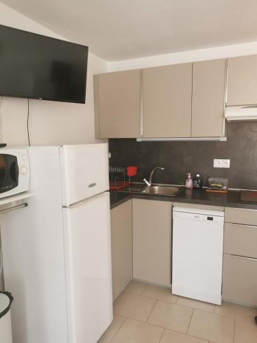 une cuisine blanche avec des armoires blanches et un évier dans l'établissement Studio Port Cap d'Agde CAP3, au Cap d'Agde