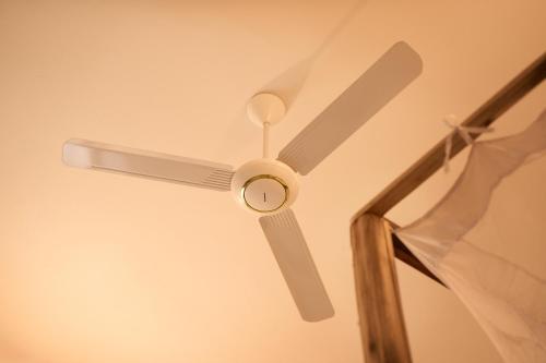 a ceiling fan sitting on a ceiling at African Bungalows in Nungwi