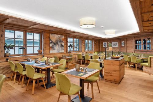 a restaurant with tables and chairs and windows at Hotel Zeppelin in Laupheim