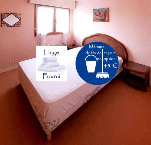 a bed in a room with a sign on it at Le Kervenel - Les Gîtes de la Côte d'Amour in Le Croisic
