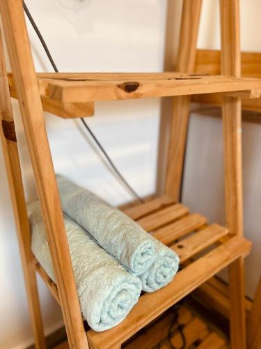 a stack of towels on a wooden shelf at Casa do Calico in Fernando de Noronha