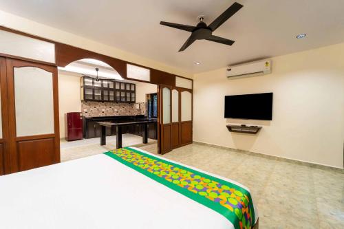 a bedroom with a bed and a flat screen tv at Treebo Grand Royale Eco Residency in Cavelossim