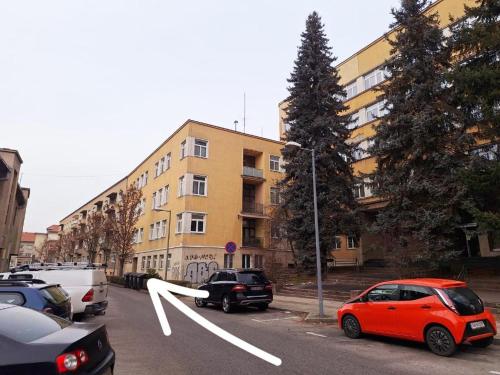 un coche rojo estacionado en un estacionamiento al lado de un edificio en Middletown apartment No 2, self check-in 24 h, en Banská Bystrica