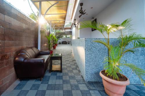 a lobby with a leather couch and a plant at Treebo Grand Royale Eco Residency in Cavelossim