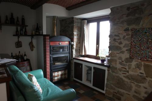 a living room with a stone stove and a couch at Al Cantello in Galati Mamertino