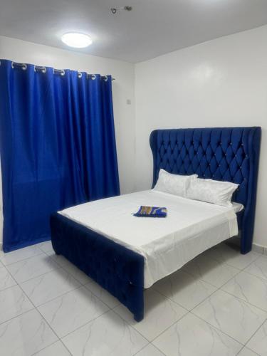 a bed with a blue headboard and a blue curtain at Sun Park Malindi - Back Villa - Black Pearl in Malindi