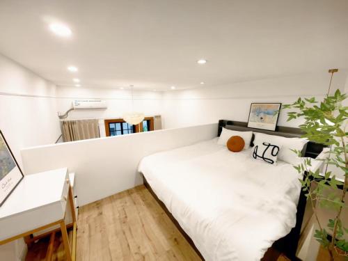 a small bedroom with a white bed and a desk at Tonight Homestay West Nanjing Road Branch Shanghai in Shanghai
