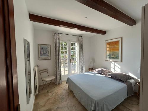 une chambre avec un grand lit et une fenêtre dans l'établissement Villa La Ventilière pour 12 Personnes avec Piscine Chauffée, Terrain de Tennis, de Pétanque et Vue Mer, au Beausset