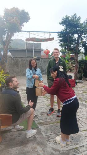 a group of people standing around a man holding a box at Tran Chau Garden Home in Cat Ba