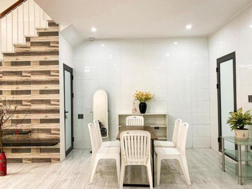 una sala da pranzo con tavolo, sedie e scala di Homestay MyLan a Lạng Sơn