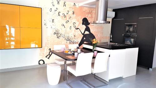 - une cuisine avec une table et des chaises blanches dans l'établissement Didalie locations mistral, à Sainte-Maxime