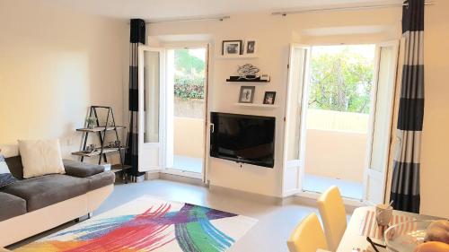 un salon avec un canapé et une télévision dans l'établissement Didalie locations mistral, à Sainte-Maxime