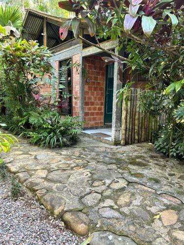 a brick house with a stone walkway leading to a door at Pousada do Oasis in Morretes