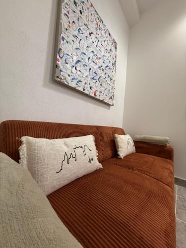 a brown couch in a room with a painting on the wall at Magnifique , appartement de plain-pied avec jardin dans le centre in Uzès
