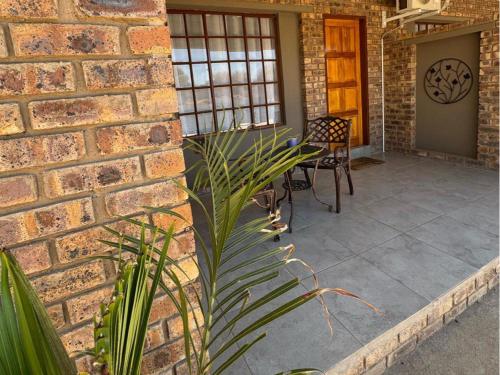 a patio with a brick wall and a table and chairs at Thabazimbi Country Lodge in Thabazimbi