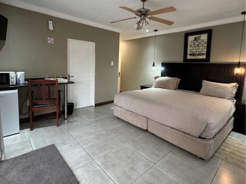 a bedroom with a large bed and a kitchen at Thabazimbi Country Lodge in Thabazimbi