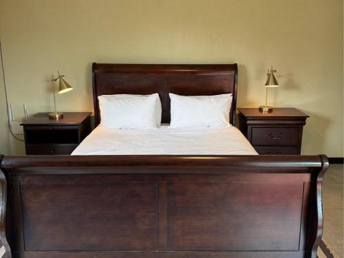 a wooden bed with two nightstands and two lamps at Thabazimbi Country Lodge in Thabazimbi