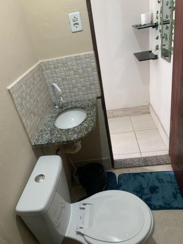 a bathroom with a white toilet and a sink at Caminho do mirante, suíte 5 in Iguaba Grande