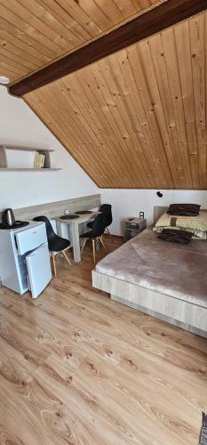 a bedroom with a bed and a wooden ceiling at Pokoje u Joli Polańczyk in Polańczyk