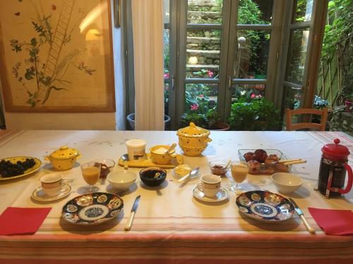 une table recouverte de assiettes et de bols de nourriture dans l'établissement les Asphodèles 3 chambres, à Saint-Hippolyte-du-Fort
