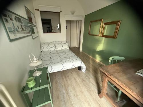 a small room with a bed and a table at Corte Arancio your home in the heart of Monferrato in Cella Monte