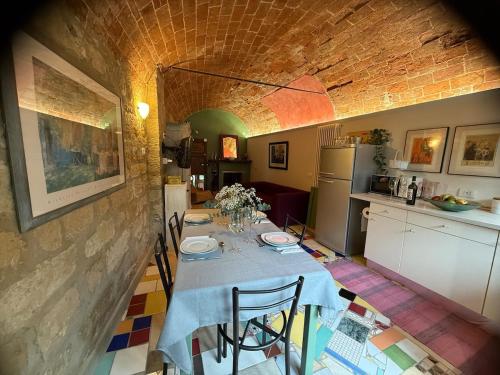 a kitchen with a table with chairs and a kitchen with at Corte Arancio your home in the heart of Monferrato in Cella Monte