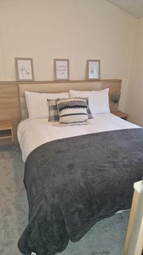 a bedroom with a large bed with a black blanket at Coastal Retreat Lodge in Morecambe