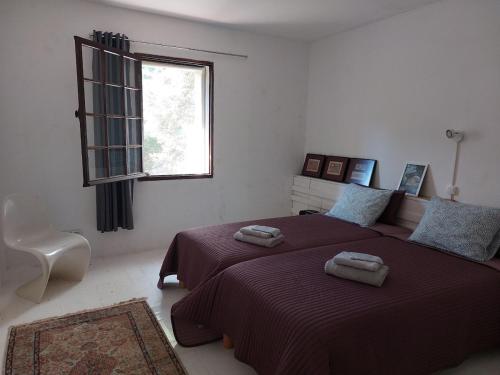 une chambre avec un lit avec deux serviettes dessus dans l'établissement Le Moulin, au Muy