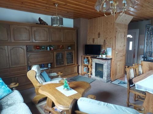 a living room with a table and a fireplace at Ferienwohnung Hähnlein in Steinach
