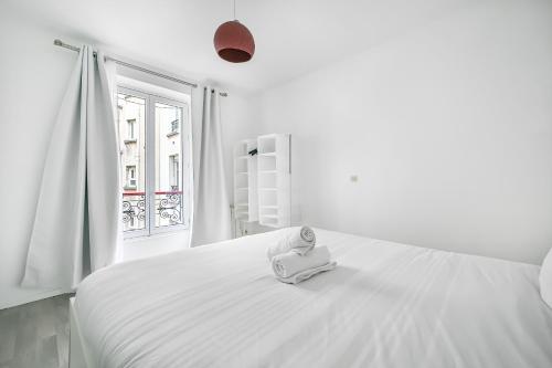 - une chambre blanche avec un lit blanc et un téléphone dans l'établissement L'Atelier Secret - Batignolles - Métro - Paris 17, à Paris