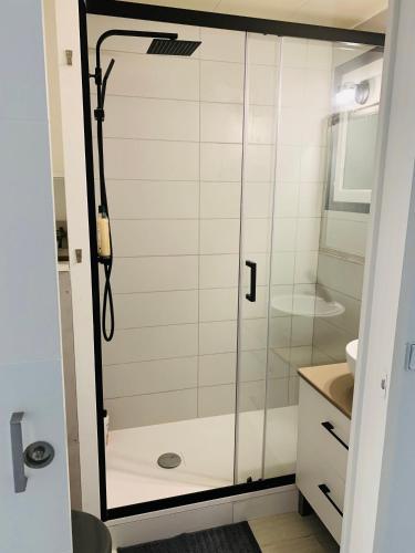 une douche avec une porte vitrée dans une salle de bain dans l'établissement Studio 