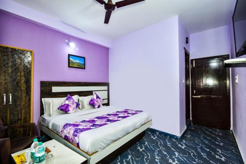 a purple bedroom with a bed and a table at Dream Guest House in Dharamshala