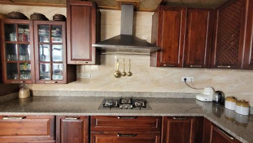 a kitchen with wooden cabinets and a stove top oven at Tara Homestay in Darjeeling