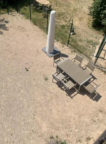 a picnic table and chairs in a field at Le Coup de Foudre Jardin - Spacieux in Sancé