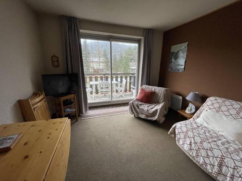 une chambre avec un lit, une chaise et une fenêtre dans l'établissement Appartement T3 avec Balcon, Barcelonnette - FR-1-804-25, à Barcelonnette