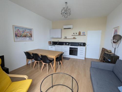 une cuisine et un salon avec une table et des chaises dans l'établissement Beau 3 pièces climatisé vue Canal idéalement situé Centre Ville, à Sète