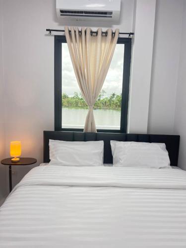 a bedroom with a large bed with a window at Sea & Sand House in Ban Khlong Khut