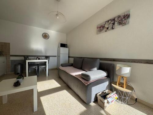 un salon avec un canapé et une table dans l'établissement Sol-y-Days Goelette, Agréable appartement en RDC avec parking, proche du centre-ville et de la plage, au Grau-du-Roi