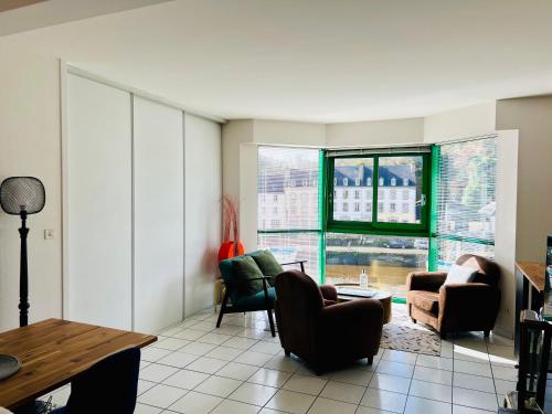 un salon avec des chaises, une table et des fenêtres dans l'établissement Voiles sur Morlaix: vue port, 4 personnes, parking, à Morlaix