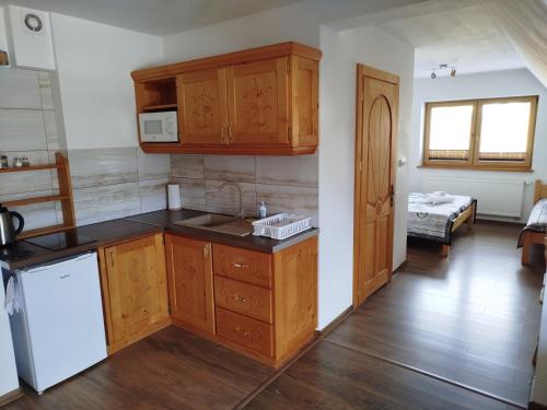 a kitchen with wooden cabinets and a white refrigerator at Chata Koziniec przy wyciągu in Czarna Góra