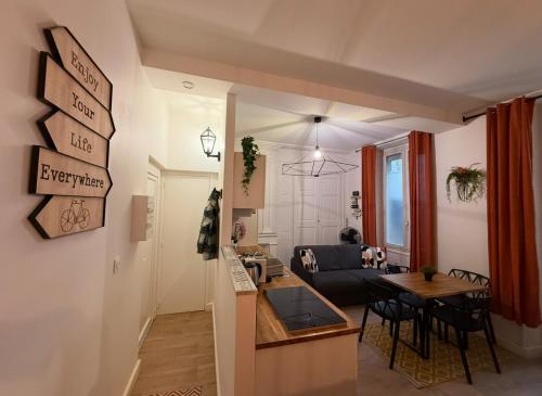a living room and a kitchen with a table and chairs at Les Studios du Centre Historique de Valence in Valence