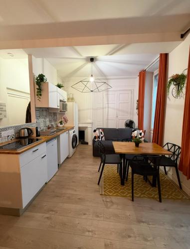 a kitchen and living room with a table and a dining room at Les Studios du Centre Historique de Valence in Valence