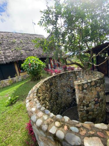 a stone retaining wall in front of a house at Finca de la Vaca - Family House in Mera