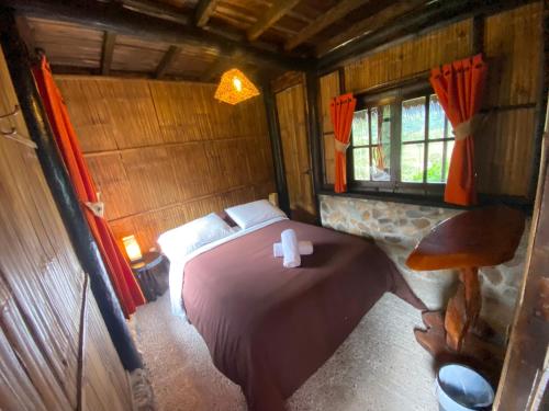 a bedroom with a bed in a wooden cabin at Finca de la Vaca - Family House in Mera