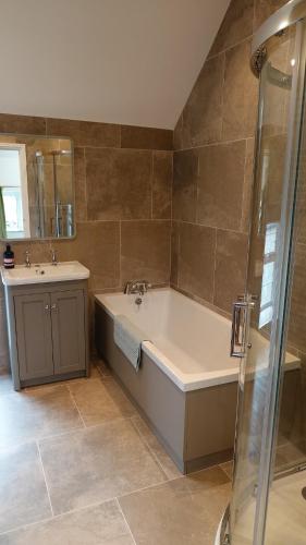 a large bathroom with a tub and a sink at Mooredge in Bonsall