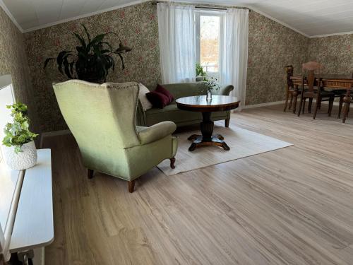 a living room with a chair and a table at Gamla Ersgården i Ersmark Umeå in Umeå